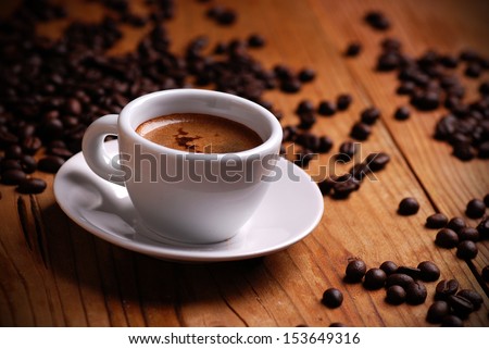 Italian espresso in white cup with coffee beans