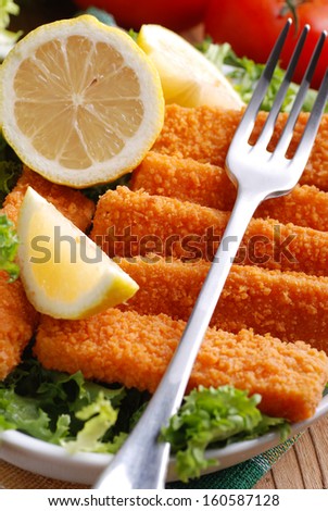 crispy fish sticks with vegetables and lemon slices
