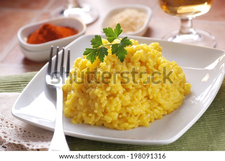 saffron risotto garnished with parsley, Italian traditional recipe