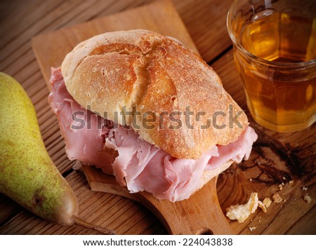 ham sandwich on wooden chopping board