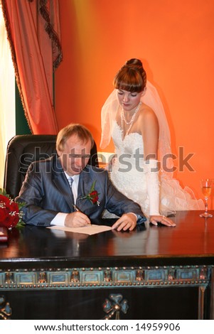 The groom puts the signature in the marriage contract