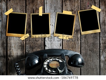 Old picture and old telephone on wood background.