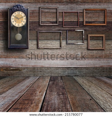 Old clock and empty picture frame in old room