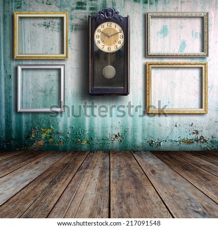 Old clock and empty picture frame in old room.