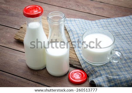 Milk bottle and milk glass put on wooden.