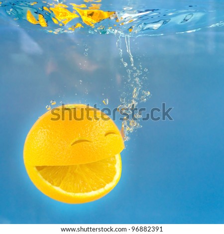 Smile orange in water drops.