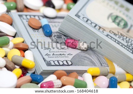 Money bundle (pack) among various drugs (pills, tablets, capsules)