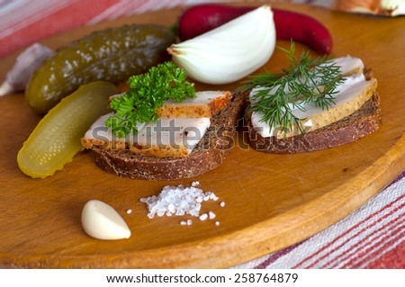 Sandwiches with salted and spiced lard served with onion, garlic and red pepper