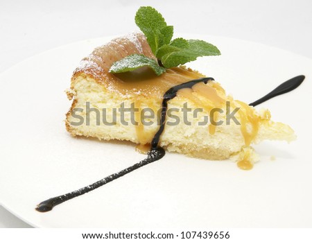 a piece of cheese cake decorated with mint leaves