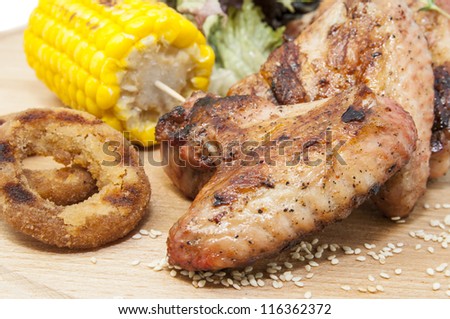chicken wings are grilled on a wooden platter