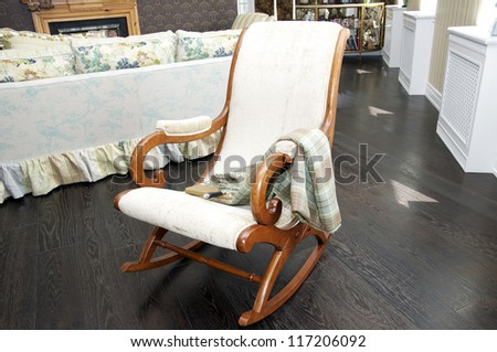 wooden rocking chair with a blanket and a book
