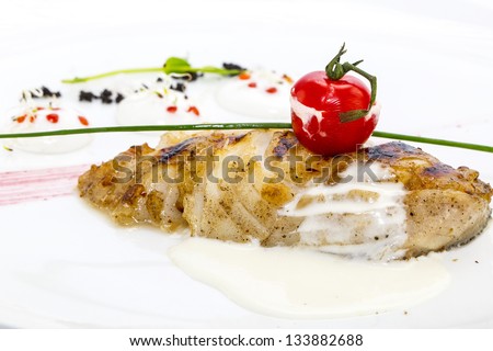Roasted fillet of grilled fish in a white sauce