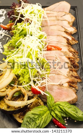 plate of meat and grilled vegetables on a white background