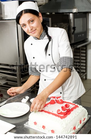 pastry chef decorates a cake in a candy store