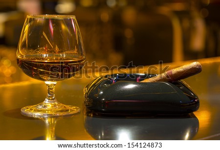 glass of brandy and a cigar at the bar