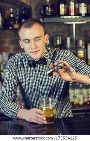 young man working as a bartender in a nightclub bar