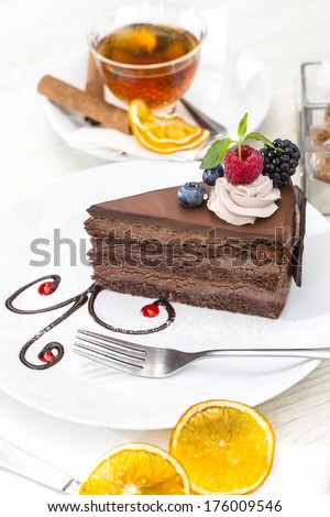 Prague piece of cake decorated with raspberries on a white background