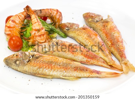grilled fish with shrimp salad on a white background in the restaurant