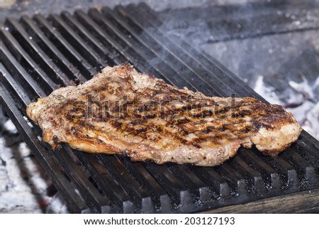 large beef steak cooked on a grill in the restaurant on the grill