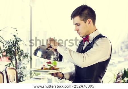 waiter with a tray of food in the restaurant hall