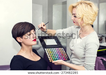 Make-up artist in the studio doing makeup beauty girl