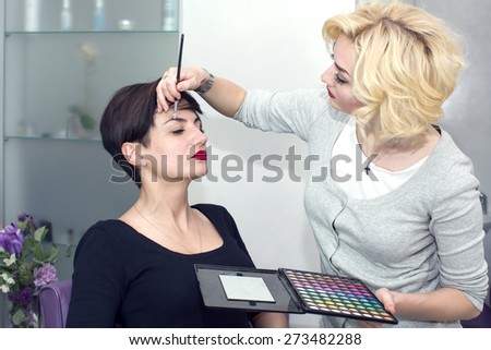Make-up artist in the studio doing makeup beauty girl