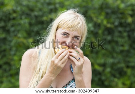 adult woman hippie woman eating a hamburger