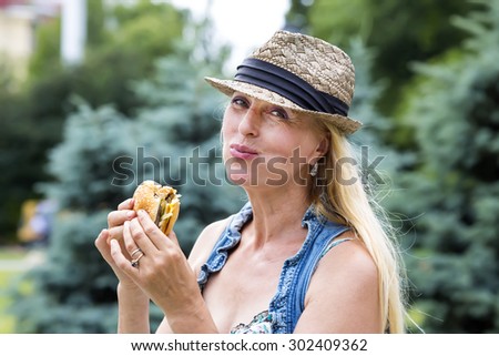 adult woman hippie woman eating a hamburger