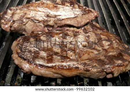 two steaks cooked on a grill in the restaurant