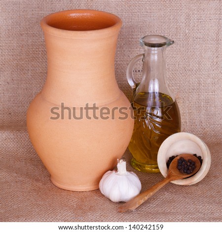 Spices, oil and pitcher against rough fabric