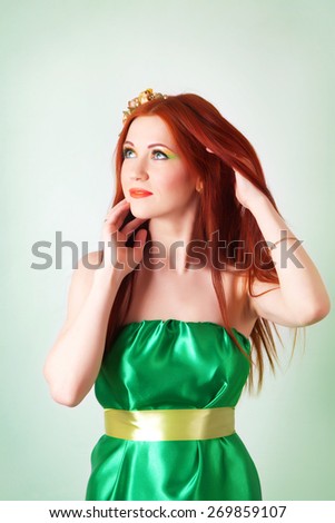 Portrait of beautiful red-haired girl with flowers in her hair and bright makeup
