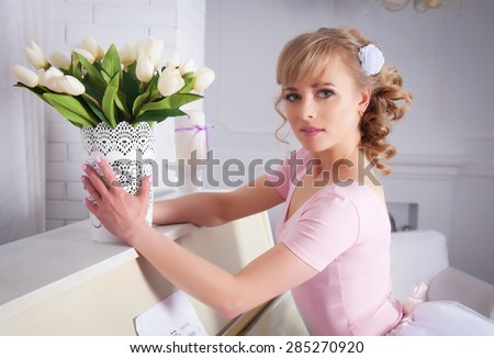 Beautiful woman with flowers near the piano