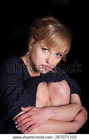Portrait of sad pensive woman on a black background