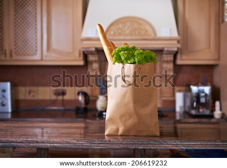 paper bag with salad and bread in the kitchen interior