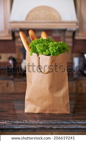 paper bag with salad and bread in the kitchen interior