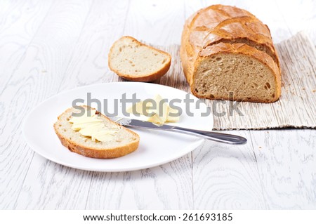 Fresh bread with butter on white table, selective focus