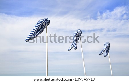 Blue and white windsock blows against a blue sky