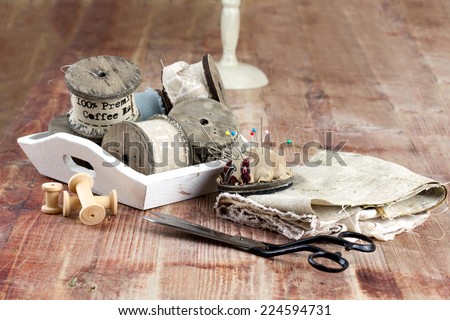 Vintage Background with sewing tools, colored tap,  Scissors and needles on the old wooden background