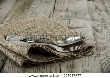 Vintage silver knife, fork and spoon on a rustic weathered table.