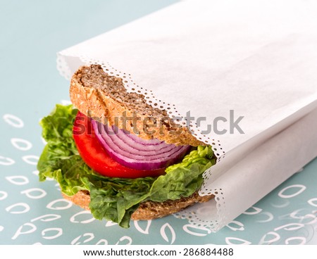 Healthy vegan sandwich wrapped in white paper