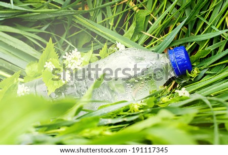 plastic bottle with water on a background of green grass