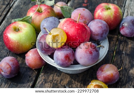 apples and plums on a wooden table