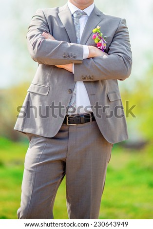 A groom putting on cuff-links as he gets dressed in formal wear