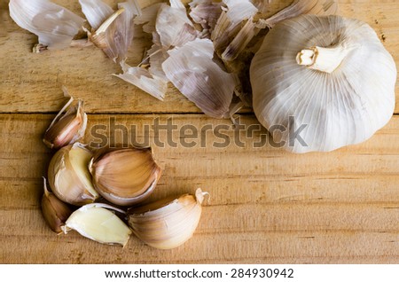 Many pieces of garlic and its peel on top of the table from the top view