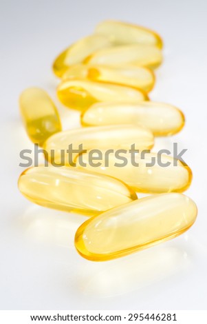 Fish oil in gold translucent capsule on white background. Fish oil which contain rich omega 3 in yellow transparent capsule on white background.