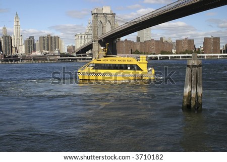 NYC water taxi drives under the Brooklyn Bridge