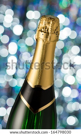 Bottle of champagne, isolated on a holiday bokeh background. Celebration. New Year Card Design with Champagne. Christmas Scene.