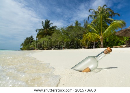 Message in a bottle washed ashore on a tropical beach.