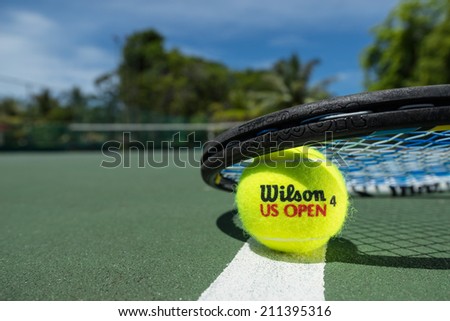 KURUMBA, MALDIVES - JUNE 21 , 2014: Photo of a brand Wilson tennis balls on clay court. Wilson - American company of sporting goods. Wilson tennis balls are official balls of Davis Cup, Fed Cup.