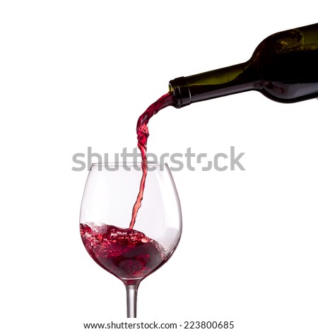 Red wine being poured into wine glass on white background